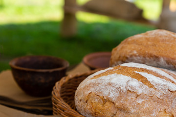 rustic food fresh big round bread on a ceramic bowl background in a summer outdoor kitchen