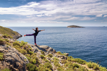 Young woman dancing and enjoying beautiful view. Kalymnos Island, Greece.