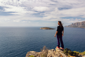 Naklejka na ściany i meble Young woman enjoying beautiful view. Kalymnos Island, Greece.