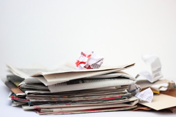 Paper waste: stack of old newspapers and pieces of cardbord and paper.