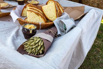 breakfast fresh baked big yellow crumb melted butter ceramic pot bunch of ears on a flax background tablecloth