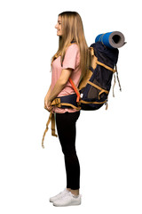 Full body Young backpacker woman in lateral position on isolated background