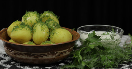 Boiled new delicious potato on plate with fresh dill on table ready to eat