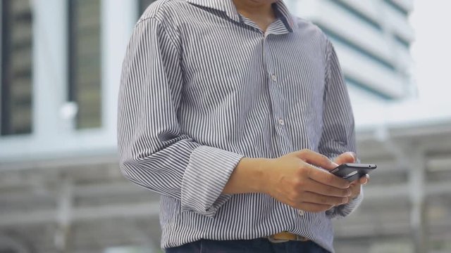 Portrait asian businessman standing texting with friend on smartphone at urban city background, Searching for social media.