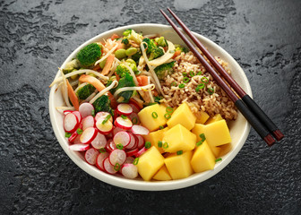 Asian style Vegan salad bowl with edamame, vegetable stir-fry mix, wholegrain rice, quinoa, mango chunks drizzled with mango, chilli dressing