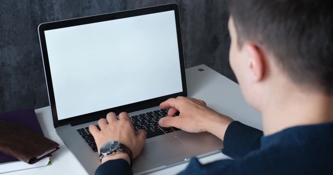 Businessman working at the computer. young man typing on laptop. Freelancer works for noutbokom.