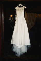Fototapeta na wymiar Detail of a white wedding dress hanging.