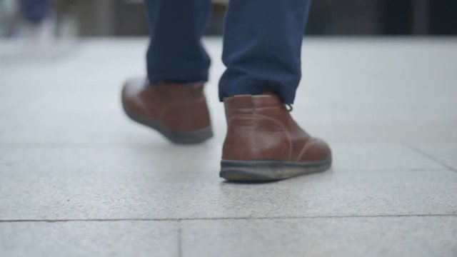 Close up of the legs asian businessman walking in the street.