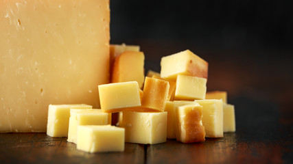 Bitesize Sliced smoked cheddar cheese on rustic wooden background