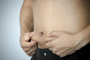 Fat young man measuring isolated over white background.