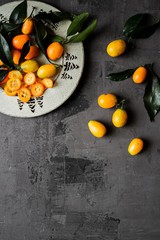 Orange fresh organic kumquats on isolated background with blue and white cloth. Citrus fruit sour...