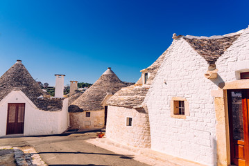 Fototapeta na wymiar Narrow streets between the trulli of Alberobello, in southern Italy, ideal for family trips.