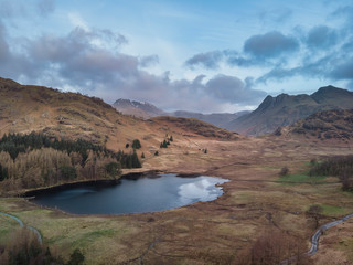 Beautiufl unique drone aerial sunrise landscape image of Blea Tarn and Langdales Range in UK Lake District