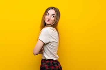 Young woman over isolated yellow wall laughing