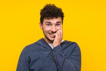 Young man over isolated yellow wall nervous and scared