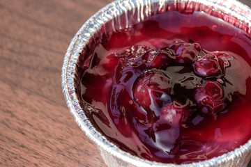 Blueburry cheese cake in foil cup (homemade) with wooden table for dessert background or texture - food concept.