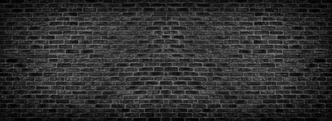 Wide black brick wall texture. Old rough brickwork panorama. Dark panoramic background