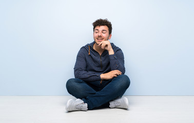 Young man sitting on the floor looking to the side