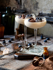Two champagne glasses with caramel colored panna cotta, jelly, mousse or pudding with chocolate and...