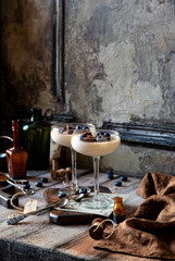 Two champagne glasses with caramel colored panna cotta, jelly, mousse or pudding with chocolate and...