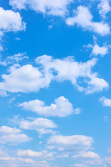 Schöner blauer Himmel mit weißen Wolken - vertikaler Hintergrund