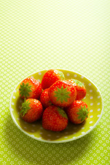 green yellow plate with fruit red strawberries with copy space