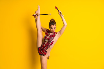 Girl doing rhythmic gymnastics with maces.