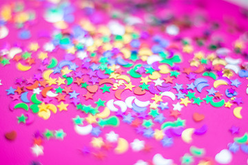 Festive party confetti on a bright colorful pink background