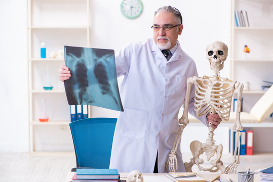 Aged male doctor with skeleton 
