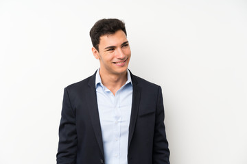 Handsome man over isolated white wall standing and looking to the side