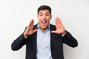 Handsome man over isolated white wall shouting with mouth wide open