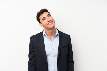 Handsome man over isolated white wall laughing and looking up