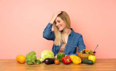 Young blonde woman with many vegetables has realized something and intending the solution