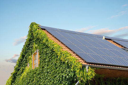 Haus mit Photovoltaik vor blauem Himmel