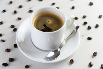 Front view of a delicious and tasty cup of freshly made coffee with coffee beans
