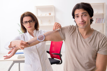 Female doctor checking patient's joint flexibility with goniometer