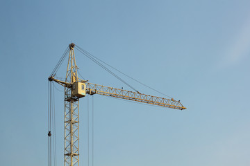 Industrial construction building crane against blue sky