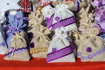 Group of textile bags with dried lavender flowers and leaves, available for sale at a traditional weekend market