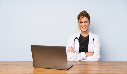 Blonde doctor woman keeping the arms crossed in frontal position