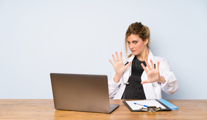 Blonde doctor woman nervous stretching hands to the front