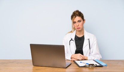 Blonde doctor woman with sad and depressed expression