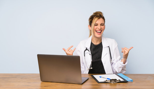 Blonde Doctor Woman Making Rock Gesture