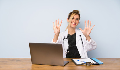 Blonde doctor woman counting nine with fingers