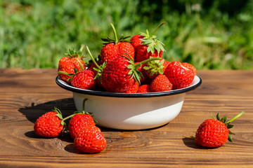 Fresh ripe strawberry on a wooden table outdoor