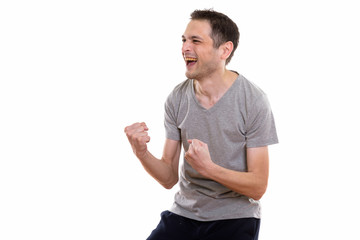 Studio shot of happy young man smiling while looking excited