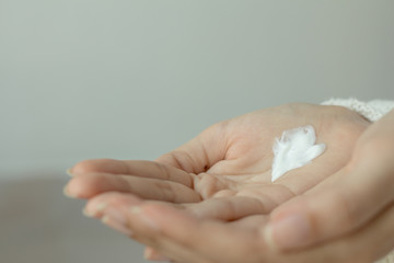 Woman hands applying hand cream moisturize the skin. The weather is cold.