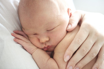 Mom and baby, newborn sleeping in mother hands