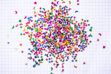 Colorful confetti hearts, stars, moons on notebook background