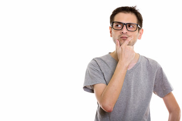 Studio shot of young man wearing eyeglasses while thinking and l