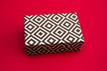Cardboard gift box isolated on a red background.